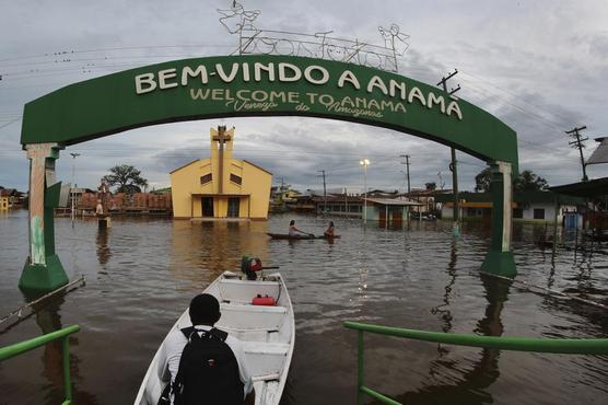 Unos residentes navegan por unas calles inundadas en Anama, en el estado de Amazonas