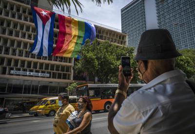 Una bandera del Orgullo Gay colgada junto a una bandera cubana en el exterior del Ministerio de Salud Pública 
