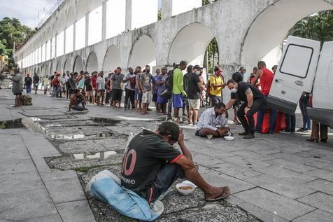 Personas sin techo reciben asistencia alimentaria en Río de Janeiro (foto: EPA)