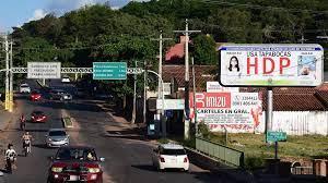 Cartel publicitario instando a usar mascarillas, en Villa Elisa, Paraguay