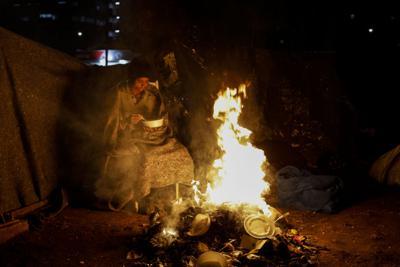 Un indigente se protege del frío junto a una fogata en Sao Paulo, Brasil