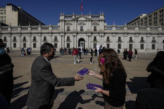 Un trabajador del gobierno entrega copias del borrador de la nueva constitución durante el lanzamiento del programa Chile Vota 