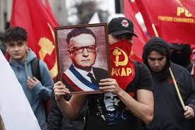 Una persona sostiene una imagen del expresidente Salvador Allende durante la marcha de ayer
