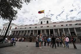 Ciudadanos ecuatorianos caminan a las afueras del Palacio de Gobierno en Quito 