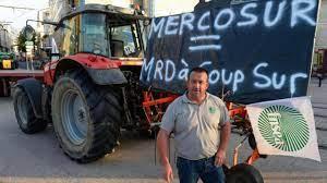 El Presidente de la Federación Nacional de Sindicatos de Agricultores, Denis Pineau con cartel que cuestiona los acuerdos