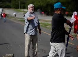 Un hombre dispara un arma hacia un manifestante en medio de un bloqueo de docentes en la vía Panamericana - EFE