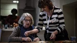 Una trabajadora de la salud (D) asiste a una paciente de Alzheimer en Estados Unidos  - AFP