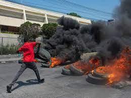 Un manifestante quema neumáticos durante una manifestación tras la dimisión del primer ministro Ariel Henry, en Puerto Príncipe,