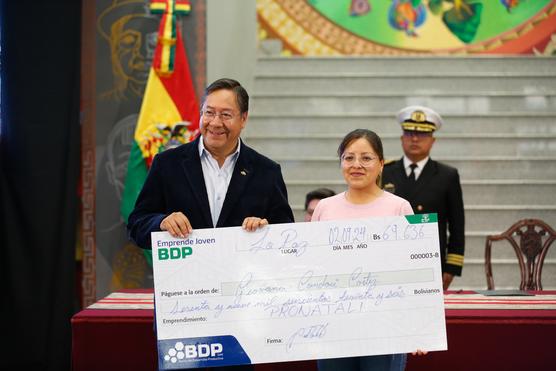 El presidente Luis Arce entregó el primer cheque simbólico a la primera beneficiaria de Focreb. Foto: Comunicación Presidencial.