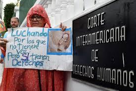 Una mujer sostiene un letrero en el exterior de la Corte Interamericana de Derechos Humanos - © Ezequiel BECERRA / AFP 